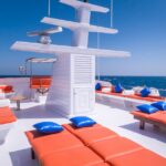 Orange sunloungers with blue cushions on the sundeck of the boat
