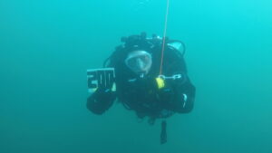 Diver underwater holding a slate marked '200'