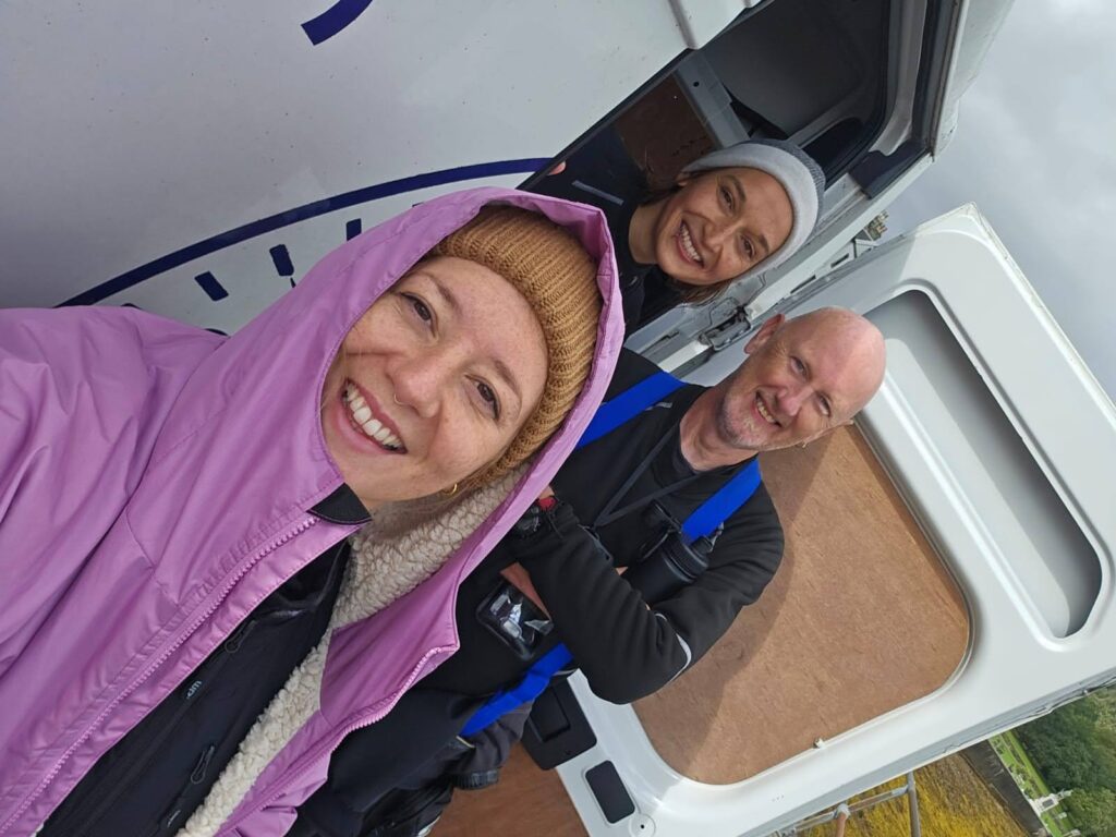 Divers in undersuits and dryrobes by the rear van doors