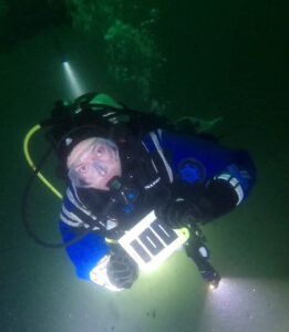 Diver with slate with '100' written on to celebrate 100th dive
